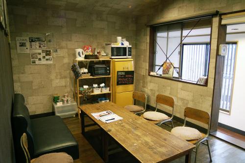 Pokój ze stołem i krzesłami oraz żółtą lodówką w obiekcie Omotenashi LAB w mieście Sakura