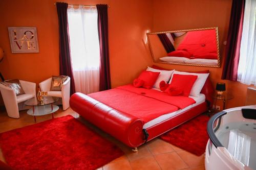 Schlafzimmer mit einem roten Bett und einem Spiegel in der Unterkunft Loveroom in Interlaken