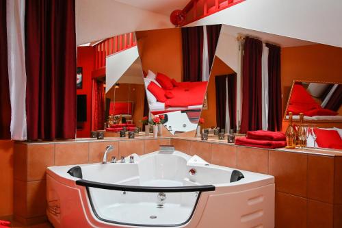 uma casa de banho com almofadas vermelhas e um espelho grande em Loveroom em Interlaken