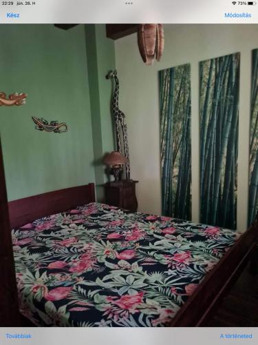 a bedroom with a bed with a floral bedspread at Diana Apartman in Balatonszepezd