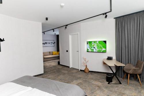 a bedroom with a bed and a tv on the wall at MM Boutique Hotel in Burgas City