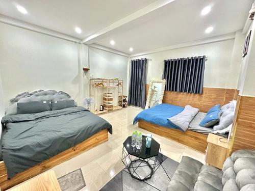 a bedroom with two beds and a couch at Cloud River Homestay in Da Lat