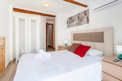 a bedroom with a large white bed with red pillows at apartamento con terraza in Valencia