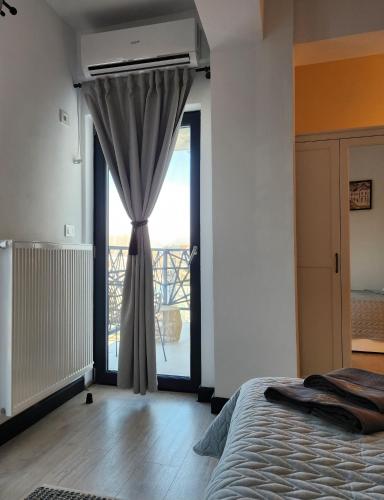 a bedroom with a bed and a large window at My room accommodation in Curtea de Argeş