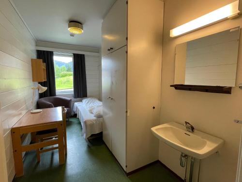un bagno con lavandino e una camera con divano di Førde Sommarhotell a Førde