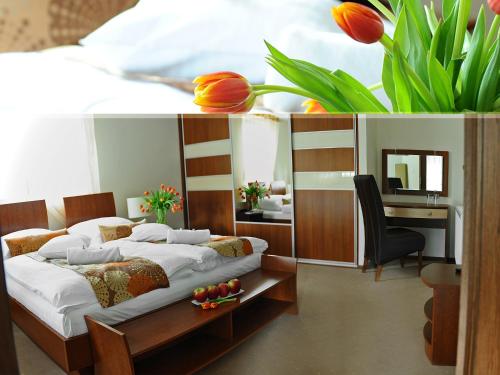 a bedroom with two beds and a desk and flowers at An-Son Apartamenty in Zielona Góra