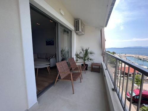 a balcony of a building with chairs and a table at Beachfront Comfort Apartments SINAJKO in Podgora