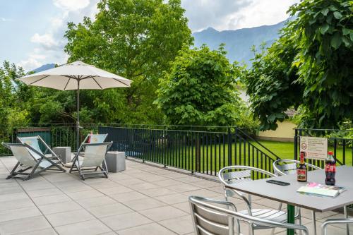 a patio with a table and chairs and an umbrella at Chalet Hostel @ Backpackers Villa Interlaken in Interlaken