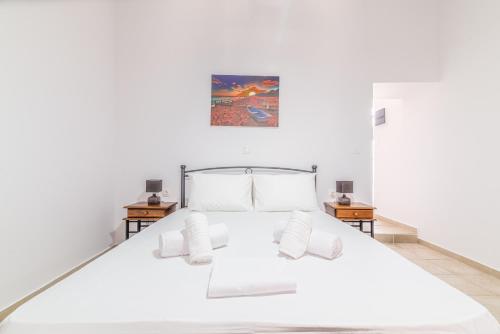 a bedroom with a white bed with two night stands at BeachFront Apt next to the Mall in Heraklio Town