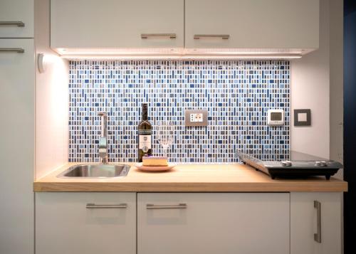 a kitchen with a sink and a bottle of wine at Main Square Apartment in Hvar
