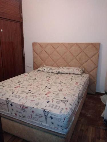 Una cama en un dormitorio con colcha. en Joli appartement de vacances, en Sale