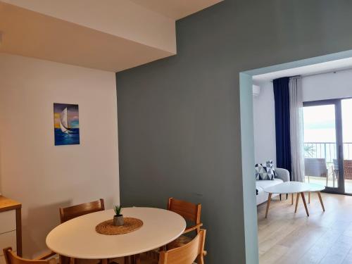 Beachfront Comfort Apartments SINAJKO في بودغورا: مطبخ وغرفة طعام مع طاولة وكراسي