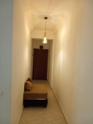 pasillo con silla en una habitación con puerta en Joli appartement de vacances, en Sale
