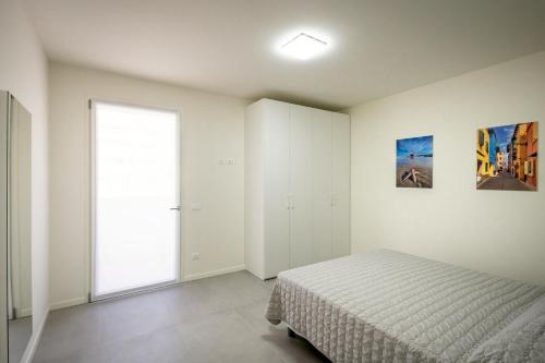 ein Schlafzimmer mit einem Bett und einem großen Fenster in der Unterkunft Residence MAXIM in Caorle