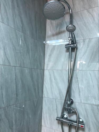 een douche met een douchekop in de badkamer bij Modern Travis House in Burnley