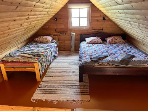 a bedroom with two beds in a log cabin at Vahtra Beach House in Käsmu