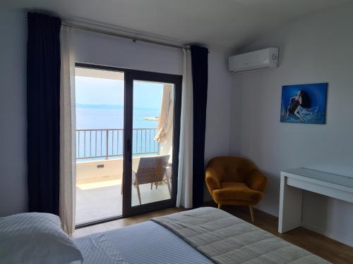 a bedroom with a bed and a view of the ocean at Beachfront Comfort Apartments SINAJKO in Podgora