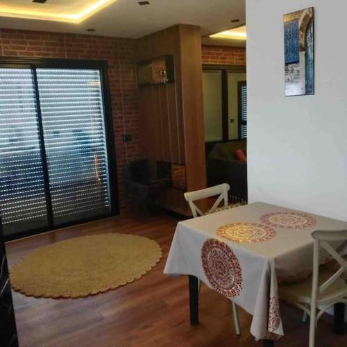 a room with a table and chairs and a living room at Bouchareb's house Ksibet el mediouni Monastir in Quşaybat al Madyūnī