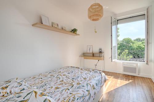um quarto com uma cama e uma grande janela em White & Wood - Charmant appartement pour 4 em Vitry-sur-Seine