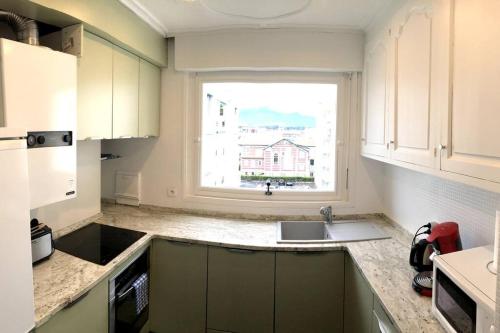 cocina con fregadero y ventana en Spacieux appartement vue Océan et Rhune, en San Juan de Luz