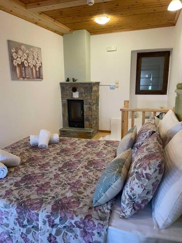 a bedroom with a large bed with a fireplace at To Patriko Mas Guesthouse-2 in Palaios Panteleimon