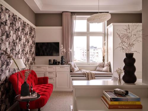 a living room with a red chair and a window at 1884 Norderney in Norderney