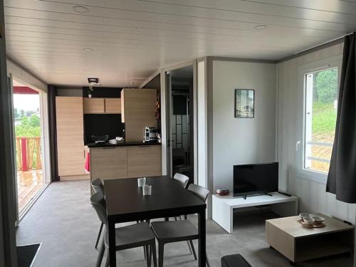 a living room with a table and a kitchen at Chalet Eguzkitsua 3 étoiles avec piscine et barbecue - pays basque - in Hasparren