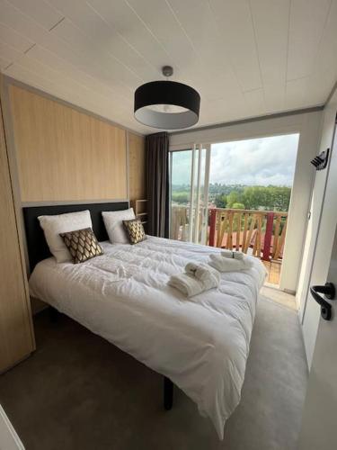 a bedroom with a large bed with a large window at Chalet Eguzkitsua 3 étoiles avec piscine et barbecue - pays basque - in Hasparren