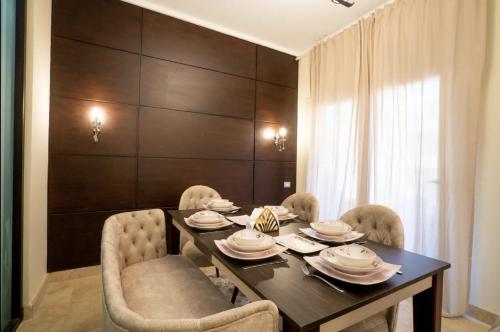a dining room with a black table and chairs at The Suites near AUC by Elegant Hospitality in Cairo