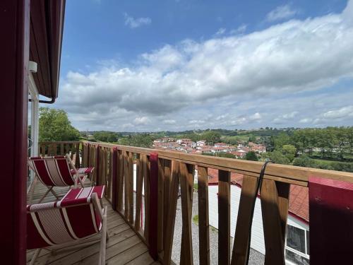 a balcony with two chairs and a view of a town at Chalet Eguzkitsua 3 étoiles avec piscine et barbecue - pays basque - in Hasparren