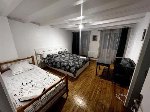 une chambre avec deux lits et une chaise dedans dans l'établissement Maison terrasse au bord de l'eau, à Ébreuil