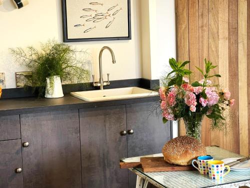 a kitchen with a sink and a vase of flowers at Charming Studio in Heart of Vibrant St Just, West Cornwall in St Just