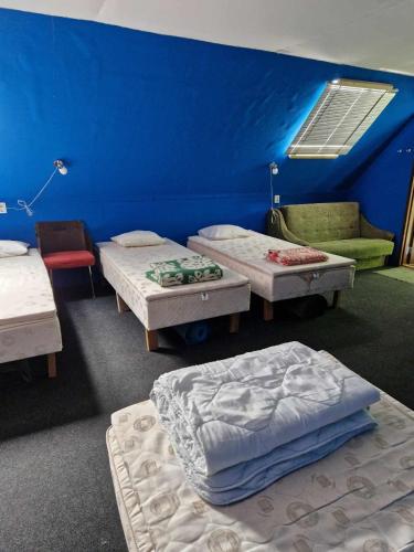 a room with three beds and a blue wall at Annimatsi Camping in Otepää