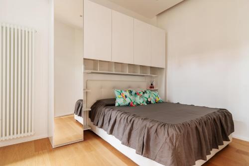 ミラノにあるLa casa sull'albero Navigliのベッドルーム(ベッド1台、白いキャビネット付)
