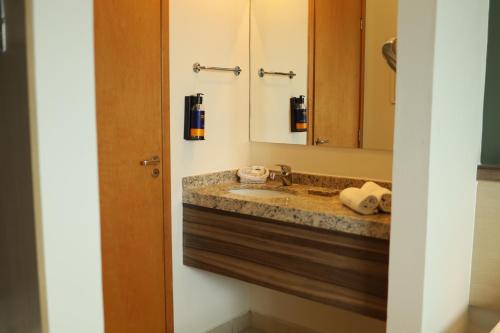 a bathroom with a sink and a mirror at Comfort Hotel Campos dos Goytacazes in Campos dos Goytacazes