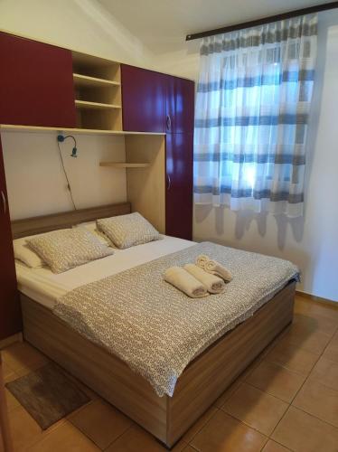 a bedroom with a bed with two towels on it at Apartmani Matjačić - Ugljan in Ugljan