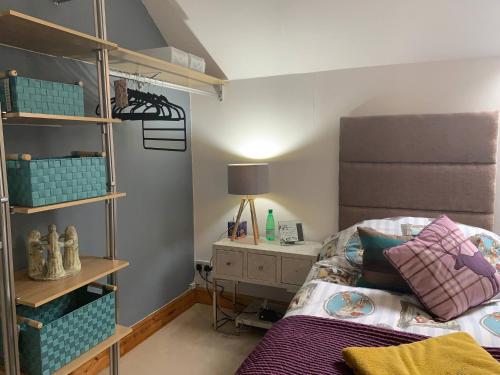 a bedroom with a bed and a book shelf at Central Scotland Country Side With Outdoor Bbq Hut in Strathaven