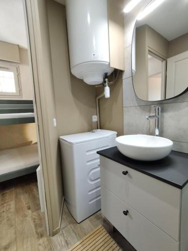 une salle de bain avec un lavabo, des toilettes et un miroir dans l'établissement Les CHÊNES appartement climatisé avec terrasse à 8mn à pieds de la plage, à Bormes-les-Mimosas