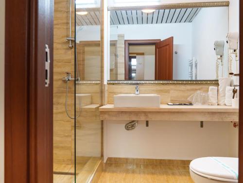 a bathroom with a sink and a toilet and a mirror at Guci Hotel in Constanţa