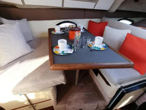 a table with two cups and plates of food on it at Dormir sur un yacht insolite in La Rochelle