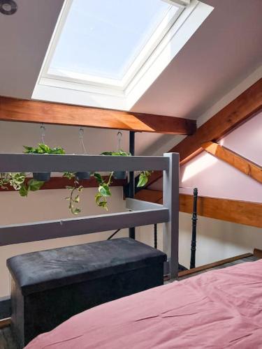 Zimmer mit einem Bett und einem Dachfenster mit Pflanzen in der Unterkunft Aplanty Nest amidst the Orchard 
