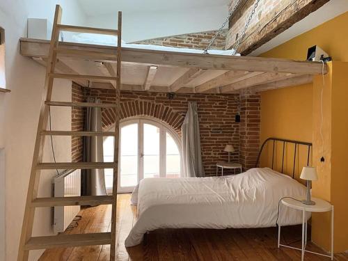 ein Schlafzimmer mit einem Etagenbett mit einer Leiter und einem Fenster in der Unterkunft NOCNOC - L'Artiste du Capitole, hyper-centre, 4 lits in Toulouse