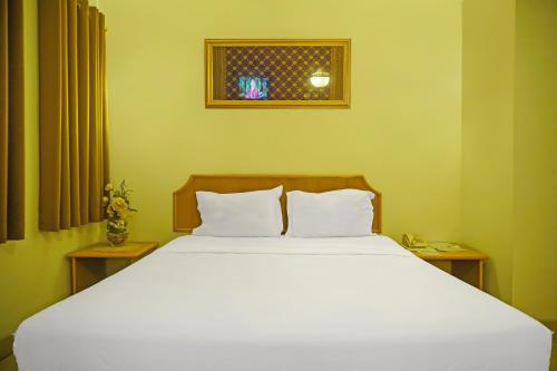 - une chambre avec un grand lit blanc et 2 oreillers dans l'établissement SUPER OYO Collection O 92690 Hotel Limas, à Palembang