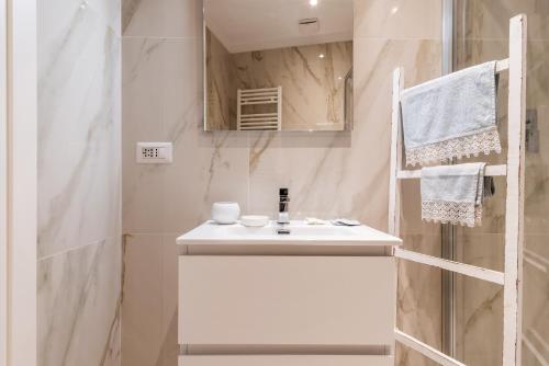 ミラノにあるLa casa sull'albero Navigliの白い洗面台とシャワー付きのバスルーム