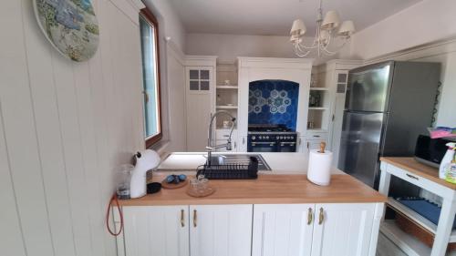 a kitchen with white cabinets and a sink and a refrigerator at Villa Caterina in Mascali