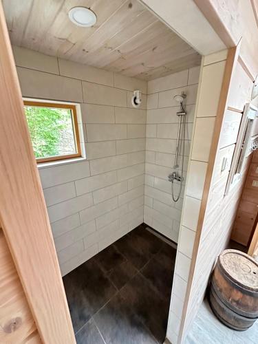 a bathroom with a shower and a barrel at Natura Sauna in Laulasmaa
