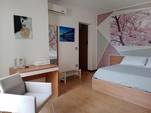 a bedroom with a bed and a desk and a chair at Vianova Affittacamere in Giurdignano