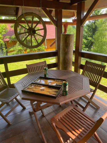 einen Tisch und Stühle auf einer Veranda mit einem Rad in der Unterkunft Cabana Transilvania in Beliş