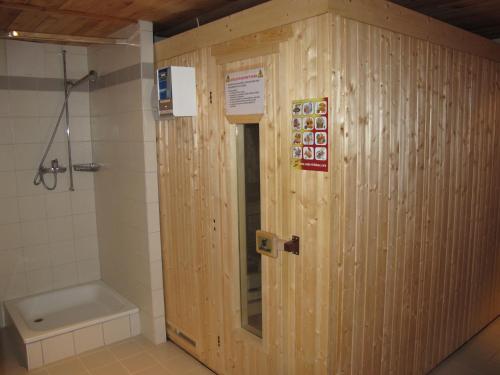 een houten badkamer met een douche en een toilet bij Wohnung CHOTTES NEND230 in Nendaz