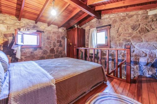 a bedroom with a bed and a stone wall at Chic Villa w Fireplace 3 min to Beach in Bodrum in Bitez